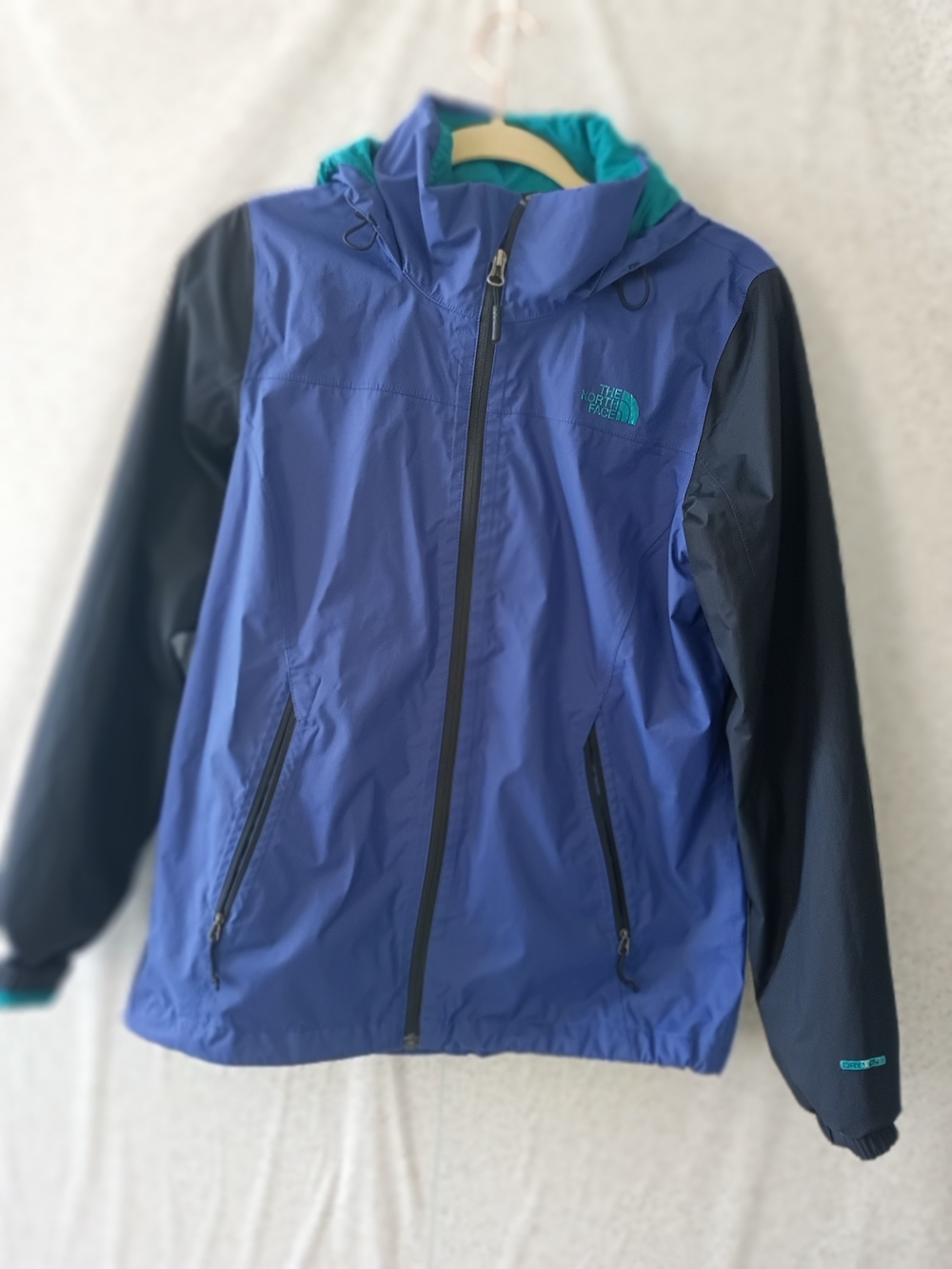 The North Face Blue Rain Jacket with Black Sleeves and Teal Hood Lining